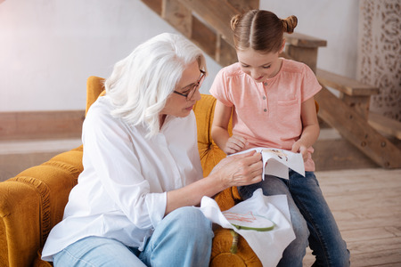 Pleasant delighted woman teaching to embroiderの写真素材