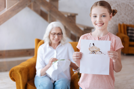 Cute happy girl showing you her embroideryの写真素材