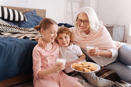 Happy delighted girl holding a plate of cookiesの写真素材