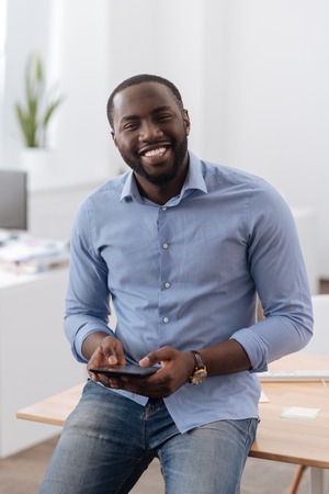 Delighted positive man holding a tabletの写真素材