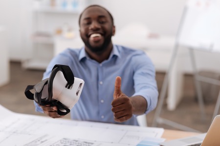 Happy positive man showing thumbs up gesture