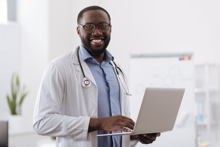 Positive professional doctor working on the laptopの写真素材