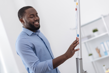 Happy nice man looking at the whiteboardの写真素材