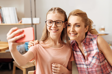 Sweet mother and daughter posing for a selfieの写真素材
