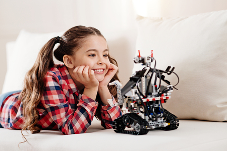 Dreamy kid leaning on her elbowsの写真素材