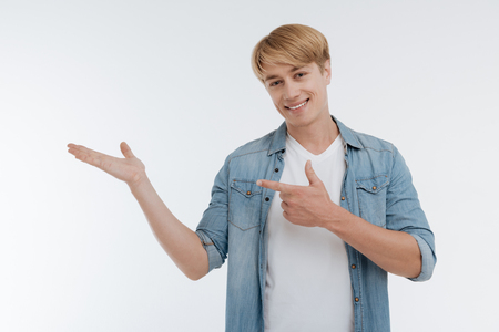 Attractive blonde male pointing at his right handの写真素材