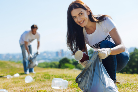 Motivated admirable woman scavenging litter on a lawnの写真素材