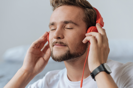 Portrait of delighted man that enjoying musicの写真素材