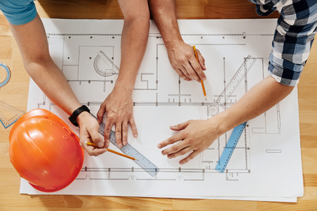 Flat lay with male hands creating a blueprint