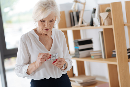 Cheerless moody woman holding pillsの写真素材