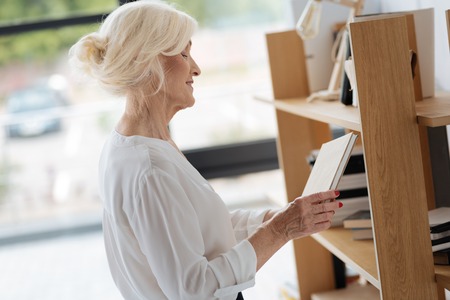 Happy delighted woman looking at the bookの写真素材