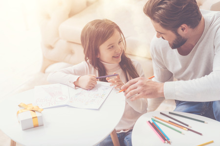 Creative cheerful girl preparing a surprise for momの写真素材