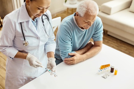 Serious experienced doctor preparing for an injectionの写真素材