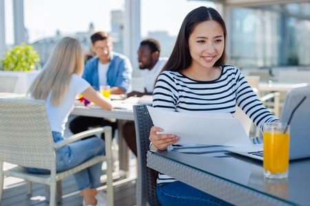 Cheerful lady studying outdoorsの写真素材