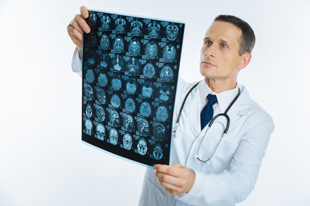 Smart male practitioner examining mri scan imageの写真素材