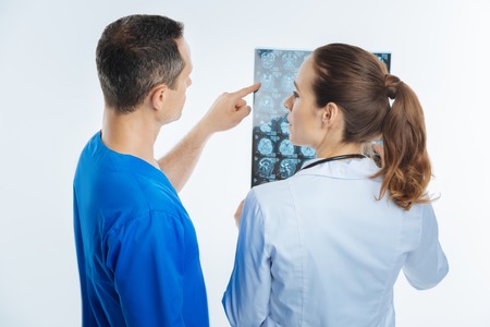 Turned back colleagues discussing mri scan image togetherの写真素材