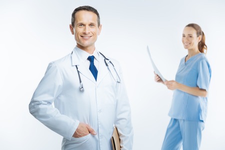 Joyful physician in white coat beaming into cameraの写真素材