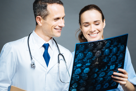 Radiant doctors looking at x ray scan image of headの写真素材