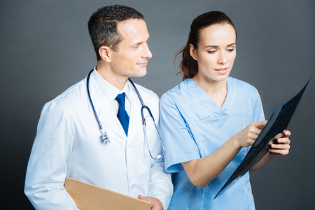 Experienced practitioners chatting over mri scan of patient brainの写真素材