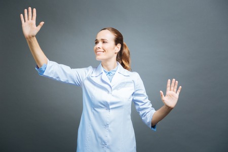Cheerful medical worker touching invisible touchscreenの写真素材