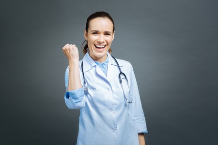 Excited female doctor getting excited into cameraの写真素材