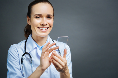 Radiant medical specialist beaming into cameraの写真素材