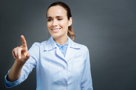 Beautiful medical professional using invisible touchscreenの写真素材