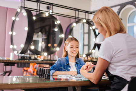 Teenage girl having her little finger filed by manicuristの写真素材