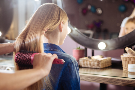 Close up of teenage girl having her hair brushedの写真素材
