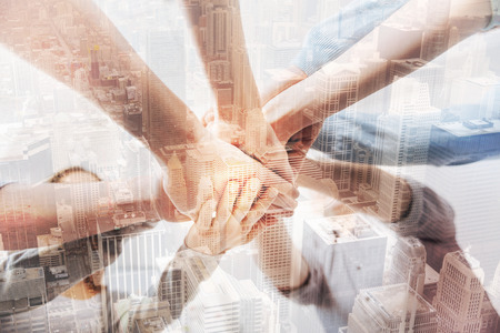 Close up of professional businesspeople holding hands togetherの写真素材