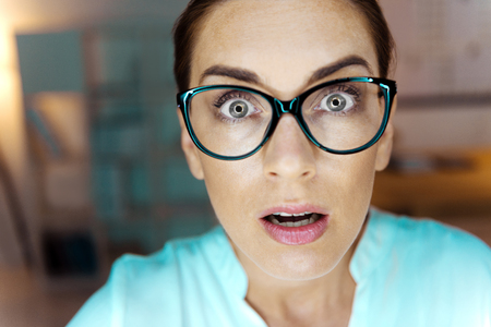Surprised woman keeping eyes wide openedの写真素材