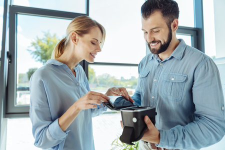 Smiling woman inserting phone into VR headsetの写真素材