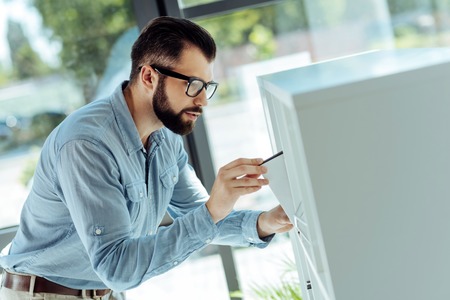 Young office worker taking folder from a cabinetの写真素材