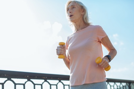 Athletic woman running with dumbbellsの写真素材