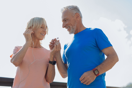 Happy elderly couple sharing one pair of headphonesの写真素材