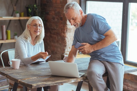 Positive loving retired couple using laptopの写真素材