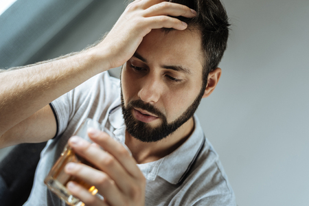 Sad unhappy man looking at his glassの写真素材