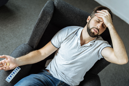 Unhappy depressed man suffering from strong painの写真素材