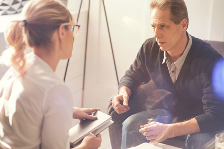 Nice gloomy man speaking with his psychologistの写真素材