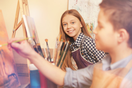 Cheerful young artists painting in art workshopの写真素材