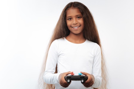 Pleasant pre-teen girl holding video game controller