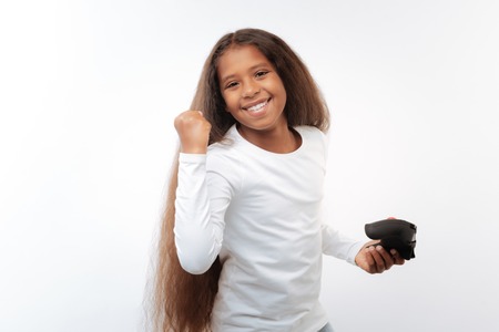 Cute pre-teen girl celebrating victory in video game