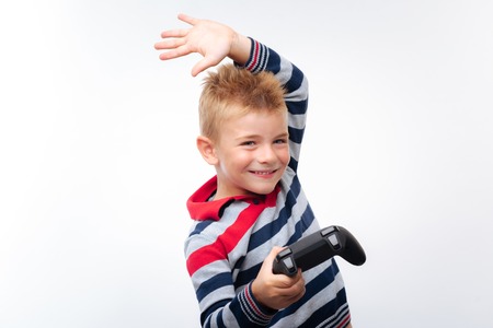 Little boy raising hand and holding game controllerの写真素材