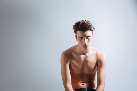 Attractive male person sitting over grey backgroundの写真素材