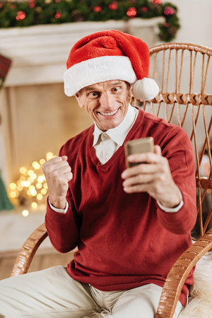 Joyful man looking at his telephoneの写真素材