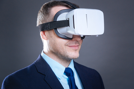 Portrait of a happy cheerful businessman wearing virtual reality glasses.の写真素材