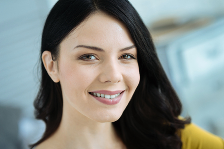 Portrait of young brunette smiling into cameraの写真素材
