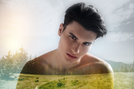 Serious teenager standing against nature backgroundの写真素材