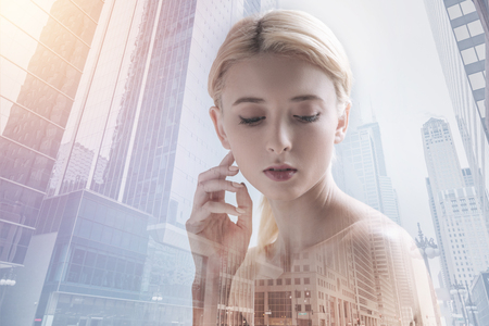 Charming girl looking down against urban backgroundの写真素材