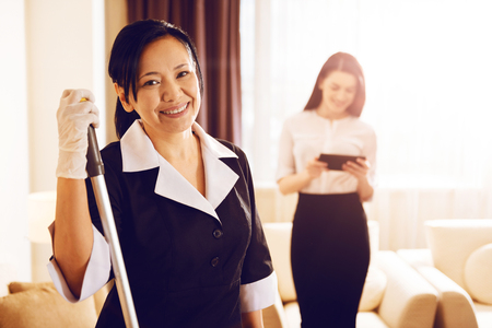 Positive delighted room cleaner posing on cameraの写真素材